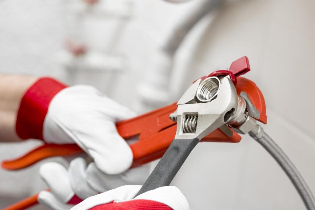 Plumber tightening pipe fitting for residential plumbing repair in Titusville, Florida