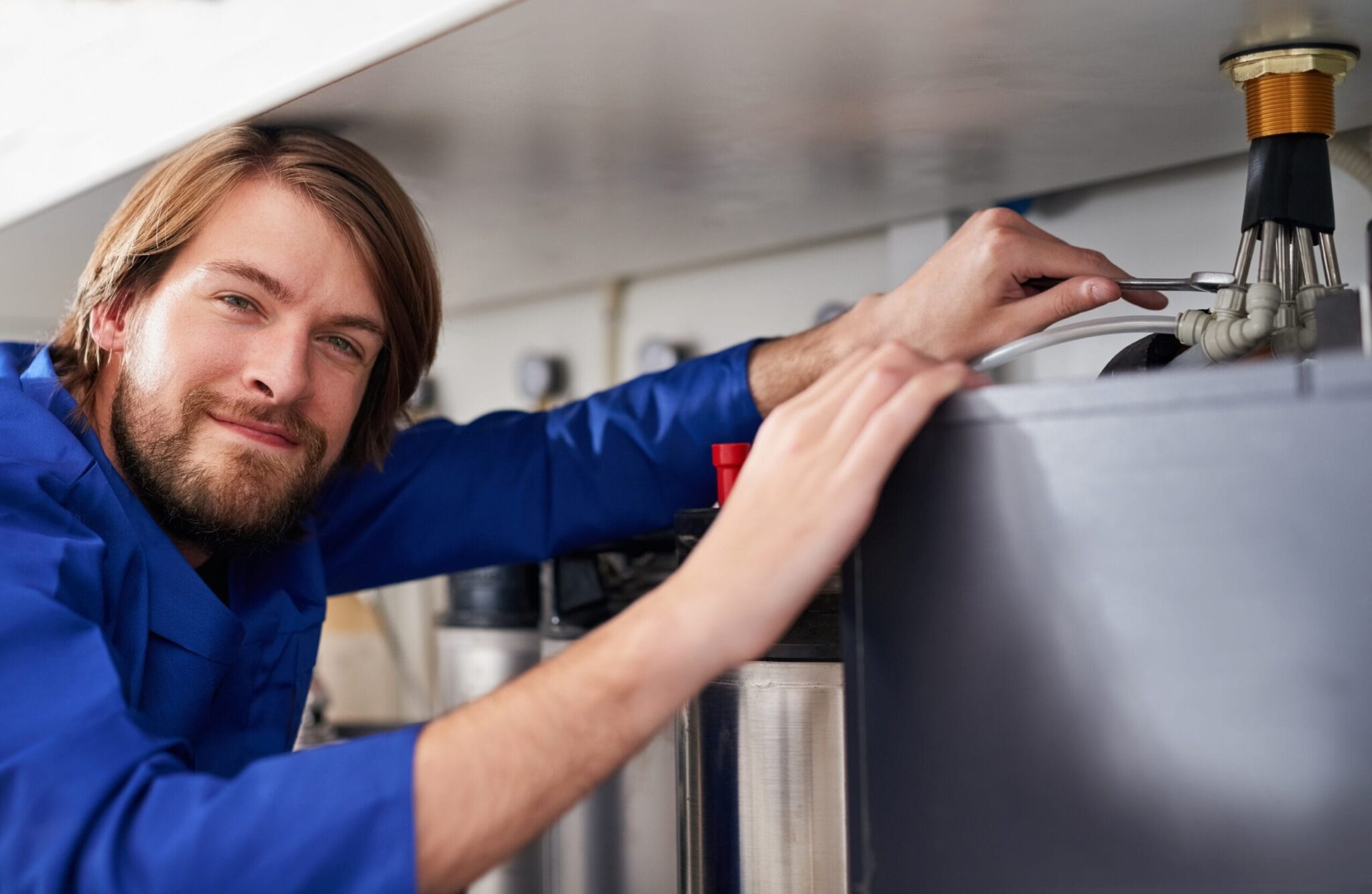 Technician servicing a residential water heater tank in Titusville